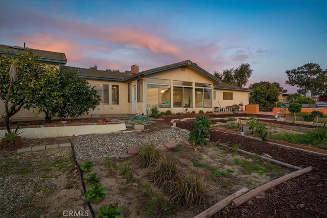 1561 Cielo Ln, Nipomo, CA 93444 - back of property at dusk with a sunroom, a chimney, and stucco siding