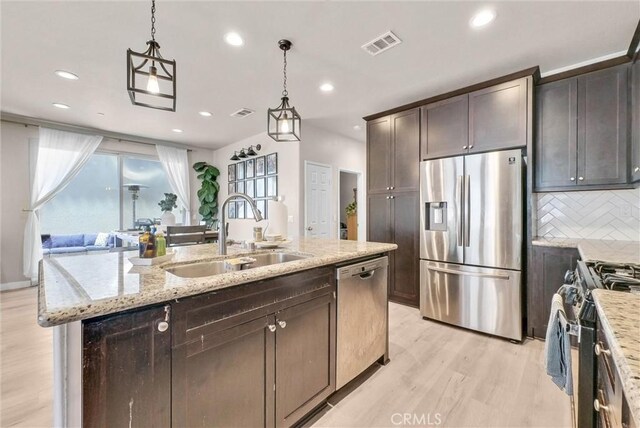 1952 Hazel Olson Ln, Colton, CA 92324 - kitchen featuring stainless steel appliances, a sink, light wood-style floors, backsplash, and light stone countertops
