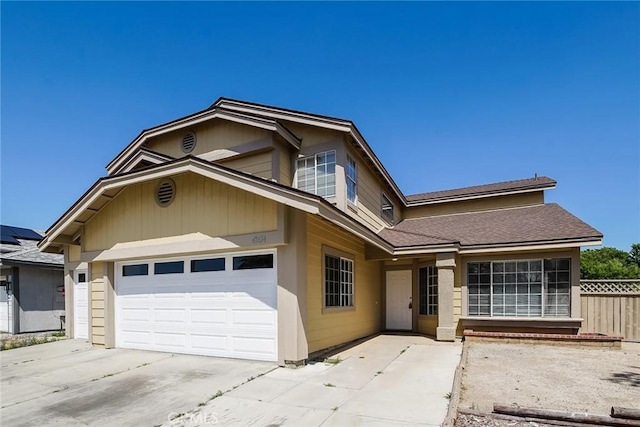 view of front facade with fence, concrete driveway, and an attached garage