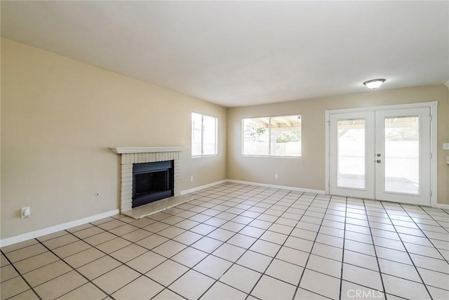 unfurnished living room featuring baseboards, a brick fireplace, french doors, and light tile patterned floors