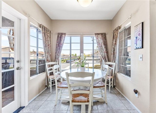 4591 Warner Ave Unit 105, Huntington Beach, CA 92649 - dining room featuring plenty of natural light, light tile patterned flooring, and baseboards