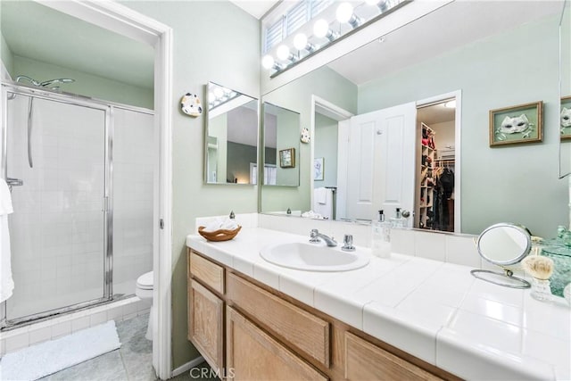 4591 Warner Ave Unit 105, Huntington Beach, CA 92649 - full bathroom featuring a shower stall, a spacious closet, vanity, toilet, and tile patterned floors