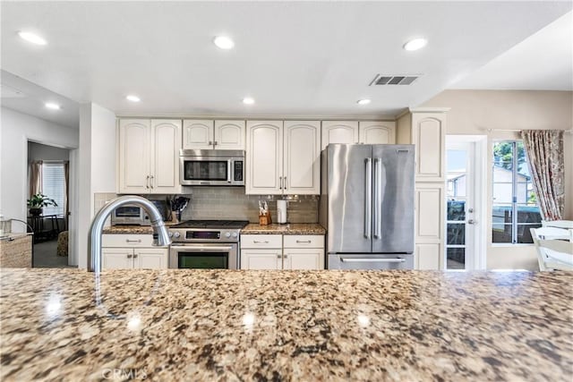 4591 Warner Ave Unit 105, Huntington Beach, CA 92649 - kitchen featuring appliances with stainless steel finishes, light stone countertops, recessed lighting, and decorative backsplash