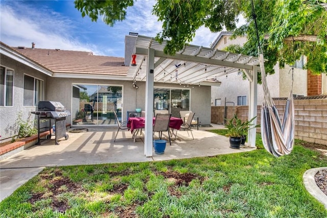 rear view of property featuring stucco siding, fence, a pergola, and a patio