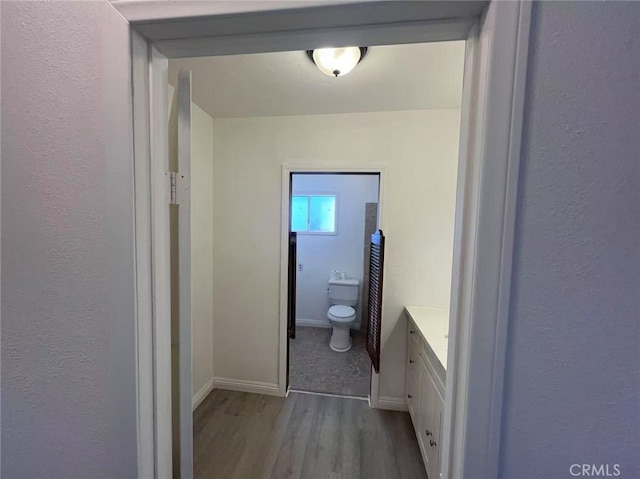 1754 Fortuna Ave, Landers, CA 92285 - bathroom featuring wood finished floors, toilet, vanity, baseboards, and a textured wall