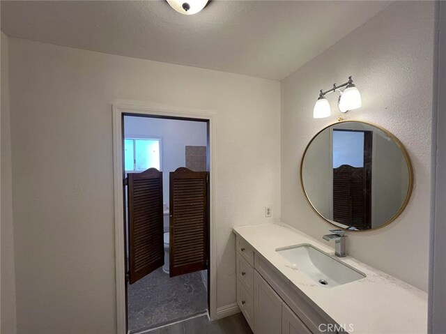 1754 Fortuna Ave, Landers, CA 92285 - bathroom with vanity, wood finished floors, baseboards, and toilet