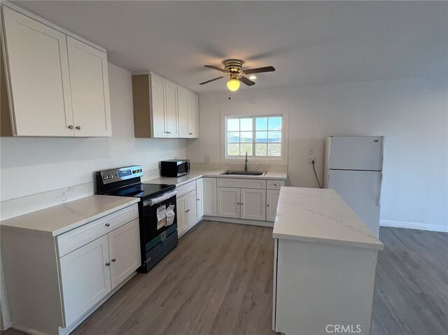 1754 Fortuna Ave, Landers, CA 92285 - kitchen with stainless steel appliances, a sink, ceiling fan, wood finished floors, and white cabinetry