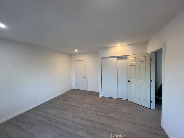 1754 Fortuna Ave, Landers, CA 92285 - unfurnished bedroom with wood finished floors, recessed lighting, a closet, and baseboards