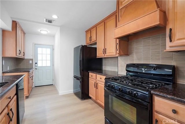 8331 Sharp Ave, Sun Valley, CA 91352 - kitchen with black appliances, premium range hood, light wood-style floors, tasteful backsplash, and dark stone countertops