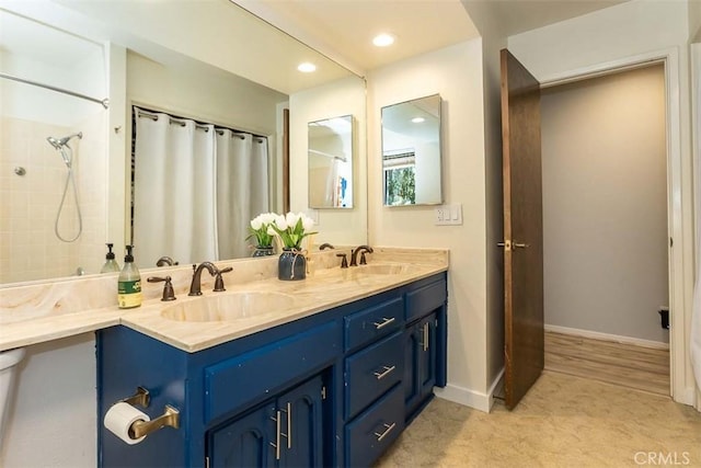 full bath featuring a shower with shower curtain, double vanity, recessed lighting, and baseboards