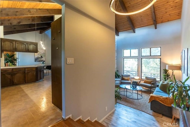 corridor with high vaulted ceiling, beamed ceiling, wooden ceiling, light wood-type flooring, and baseboards