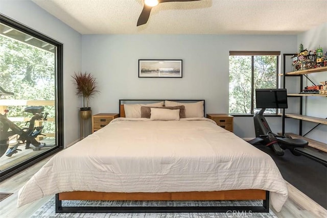 bedroom with a textured ceiling, wood finished floors, and a ceiling fan