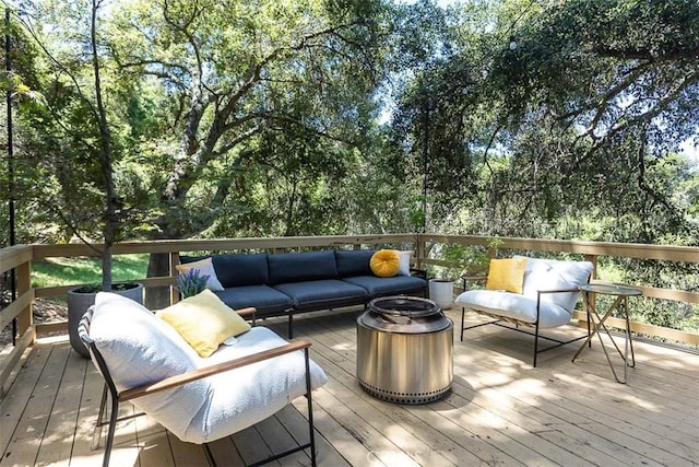 wooden deck with an outdoor living space with a fire pit