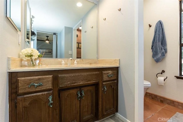bathroom featuring toilet, vanity, baseboards, and tile patterned floors