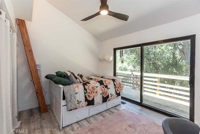 bedroom with access to exterior, wood finished floors, lofted ceiling, and ceiling fan