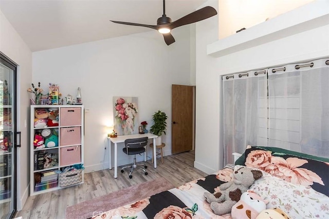 bedroom with wood finished floors, high vaulted ceiling, a desk, ceiling fan, and baseboards