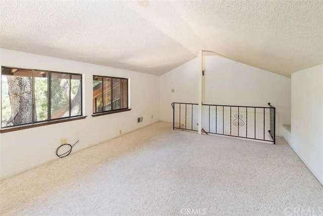bonus room featuring a textured ceiling, carpet floors, and lofted ceiling