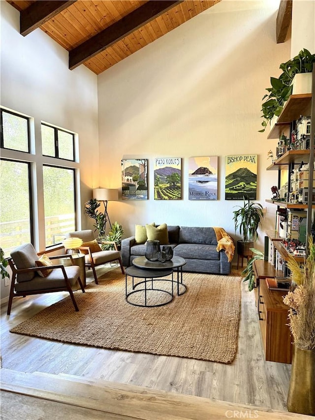 living area featuring wood finished floors, high vaulted ceiling, wooden ceiling, and beamed ceiling