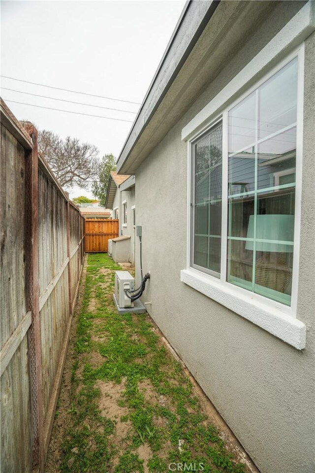 4110 E Vermont St, Long Beach, CA 90814 - view of side of property with stucco siding, a fenced backyard, and a cooling unit