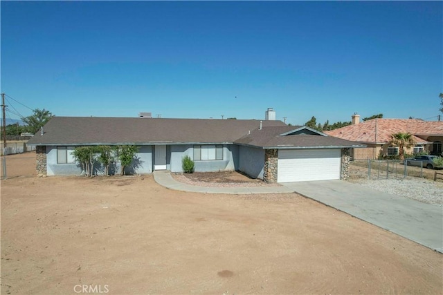 14410 Navajo Rd, Apple Valley, CA 92307 - ranch-style home featuring a garage, driveway, fence, and stone siding