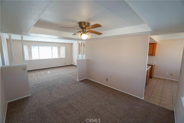 14410 Navajo Rd, Apple Valley, CA 92307 - spare room featuring a ceiling fan, light carpet, baseboards, a raised ceiling, and light tile patterned floors