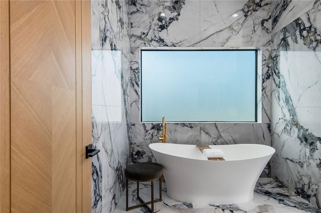 5132 Lindley Ave, Encino, CA 91316 - bathroom featuring marble tiled flooring, plenty of natural light, a soaking tub, and stone wall