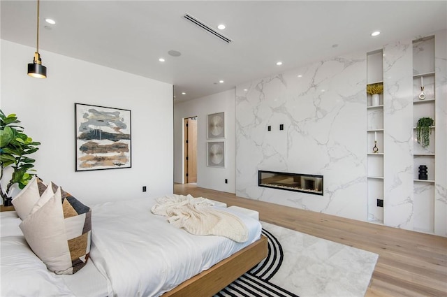 5132 Lindley Ave, Encino, CA 91316 - bedroom with recessed lighting, a high end fireplace, and wood finished floors