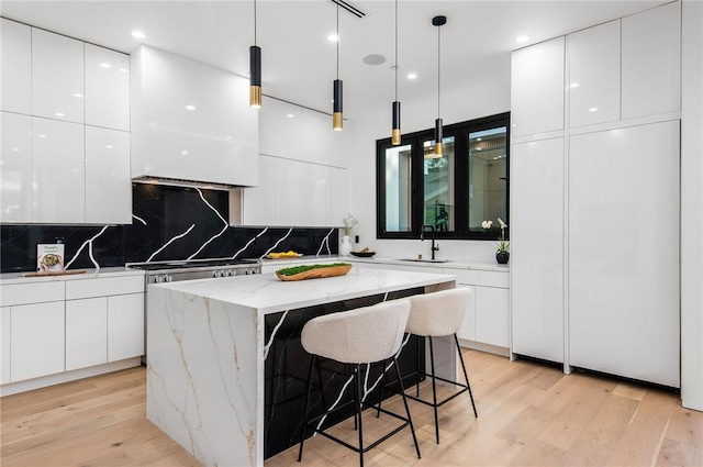 5132 Lindley Ave, Encino, CA 91316 - kitchen featuring modern cabinets, white cabinetry, light wood-style floors, and a center island