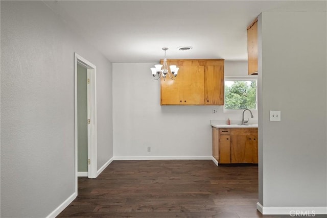 2880 Foothill Blvd, Oroville, CA 95966 - unfurnished dining area featuring dark wood-style floors, a chandelier, a sink, and baseboards