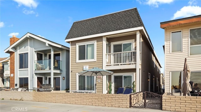 402 E Oceanfront, Newport Beach, CA 92661 - back of house featuring a balcony, roof with shingles, and a chimney