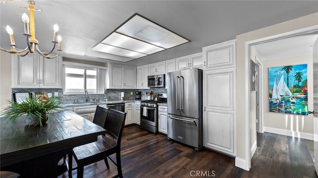 402 E Oceanfront, Newport Beach, CA 92661 - kitchen with appliances with stainless steel finishes, a chandelier, a sink, and dark wood finished floors