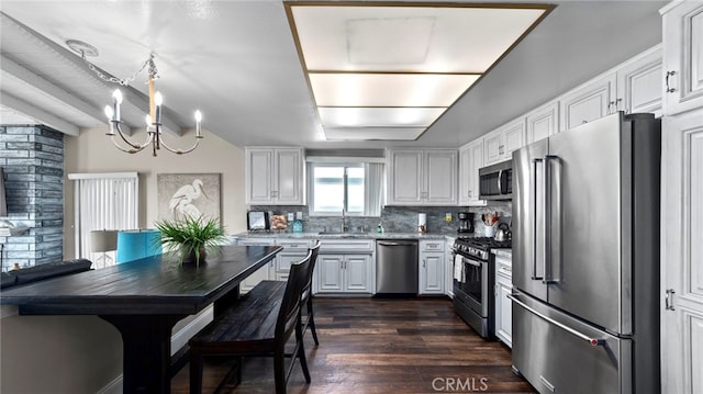 402 E Oceanfront, Newport Beach, CA 92661 - kitchen with appliances with stainless steel finishes, a sink, a chandelier, decorative backsplash, and dark wood-style floors
