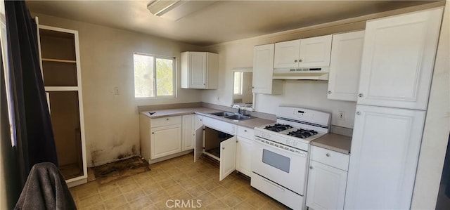 7067 Tamarisk Ave, Yucca Valley, CA 92284 - kitchen with white range with gas cooktop, under cabinet range hood, a sink, white cabinets, and light countertops