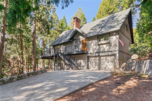 300 Pioneer Rd, Lake Arrowhead, CA 92352 - view of front of property featuring an attached garage, concrete driveway, stairway, a chimney, and roof with shingles