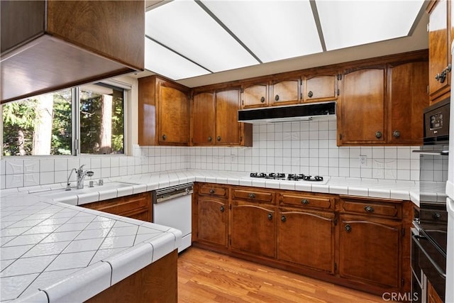 300 Pioneer Rd, Lake Arrowhead, CA 92352 - kitchen with white appliances, a sink, backsplash, brown cabinetry, and light wood finished floors