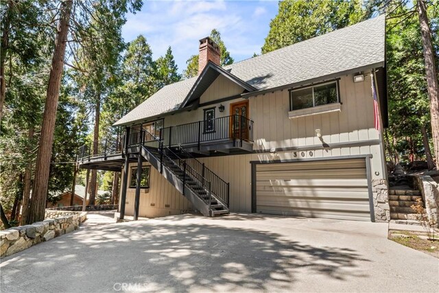 300 Pioneer Rd, Lake Arrowhead, CA 92352 - rustic home with roof with shingles, a garage, concrete driveway, stairs, and a chimney