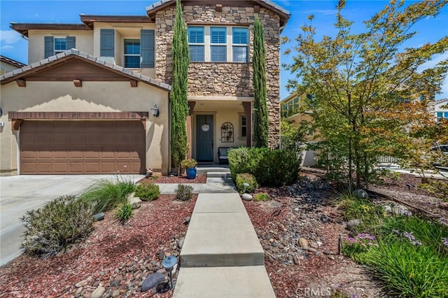 view of front of home with stucco siding, stone siding, driveway, and a garage