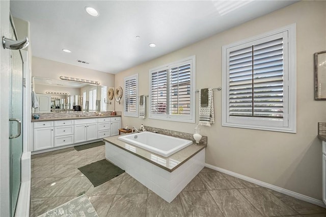 bathroom with vanity, a stall shower, baseboards, a garden tub, and recessed lighting