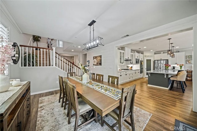 dining area with a chandelier, stairway, wood finished floors, and recessed lighting