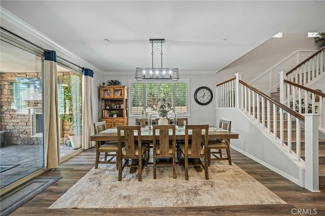 dining room featuring stairway, wood finished floors, plenty of natural light, a chandelier, and ornamental molding
