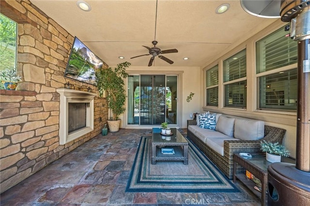 view of patio / terrace featuring an outdoor living space with a fireplace and ceiling fan