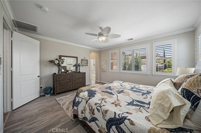 bedroom with wood finished floors, ornamental molding, and ceiling fan