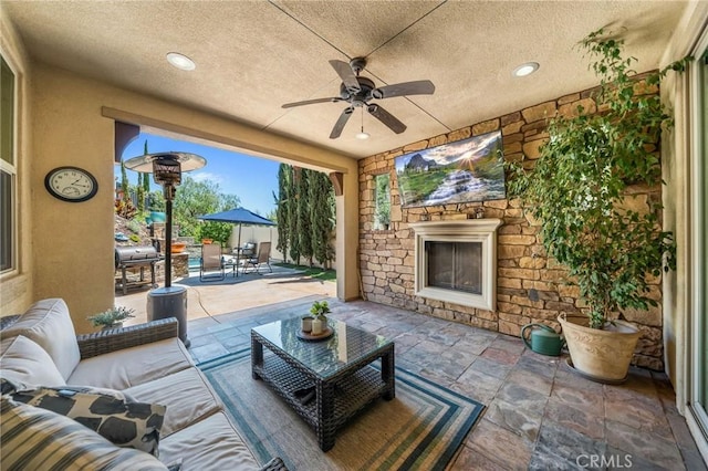 view of patio / terrace with an outdoor living space with a fireplace, outdoor dining space, and ceiling fan