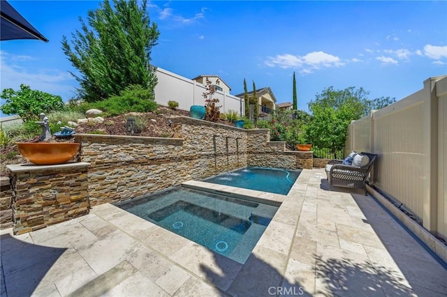 view of swimming pool featuring an in-ground hot tub, a patio, and a fenced backyard