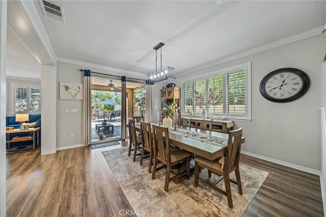dining room featuring crown molding, plenty of natural light, wood finished floors, and baseboards