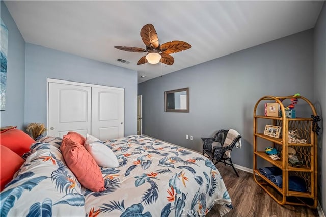 bedroom with wood finished floors, a closet, a ceiling fan, and baseboards