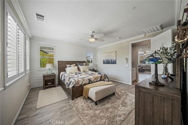 bedroom featuring baseboards, light wood-style flooring, ornamental molding, and a ceiling fan