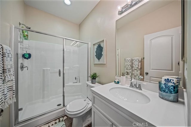 full bath featuring a stall shower, vanity, and toilet