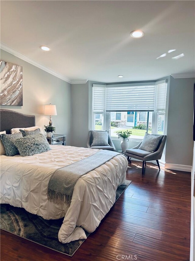 bedroom with crown molding, wood finished floors, recessed lighting, and baseboards
