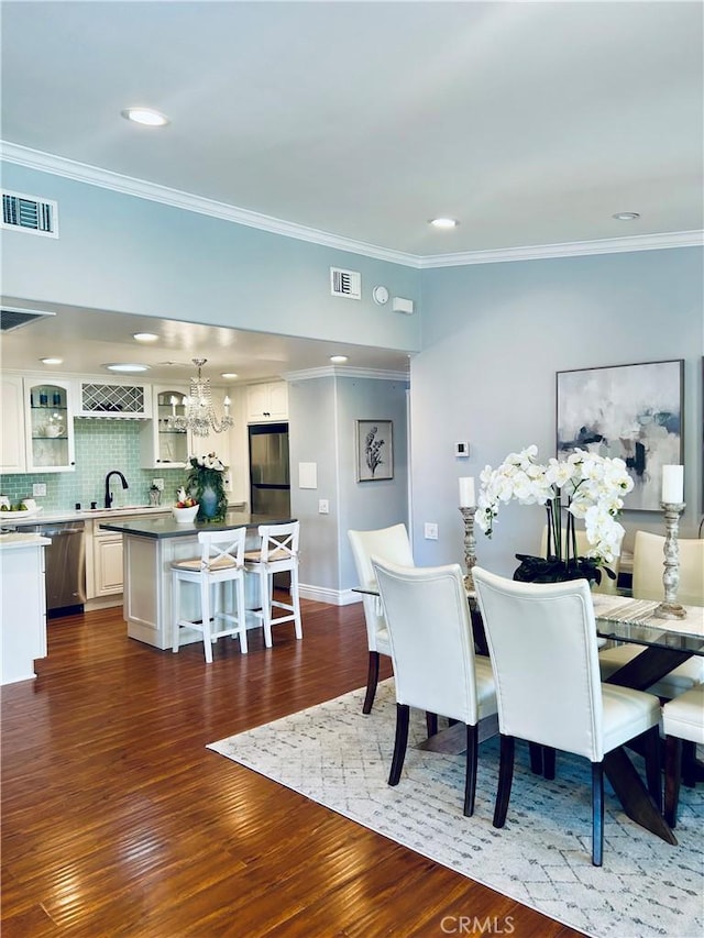 dining area with crown molding, dark wood-style floors, a chandelier, recessed lighting, and baseboards